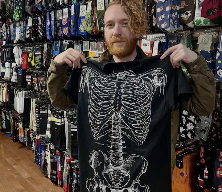 Robert Fudgina, teacher and rock frontman, picks up a tee.